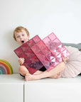 Child excitedly holding Pastel Pink & Berry Base Plate 2 pc, showcasing its vibrant colors and design possibilities.