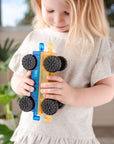 Child holding a colorful vehicle made from the Rainbow Car Pack 2 pc, featuring rubber wheels and a bright design.