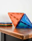 Colorful geometric shapes from the Rainbow Geometry Pack 30 pc arranged on a wooden table, showcasing vibrant play.
