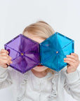 Child holding two colorful hexagon tiles from the Rainbow Geometry Pack 30 pc, showcasing vibrant play and creativity.