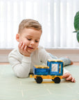 Child playing with a toy truck on a tiled floor