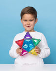 Child holding a colorful Light Star Pack 28 pc tile against a blue background, showcasing its vibrant design.