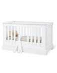 Cot bed 'Emilia' in classy matt white finish with elegant detailing and removable bars for easy access.