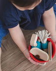 Child holding a colorful bucket filled with wooden toys from a Cleaning Set, promoting imaginative play and responsibility.