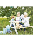 Children enjoying a picnic at the Nicki picnic bench in a grassy outdoor setting.
