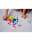 Child playing with My Mood Memo emotions lotto on a soft carpet, matching expressive wooden tokens.