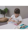 Child exploring dental care with PlanToys Dentist Set, brushing and playing with removable teeth.