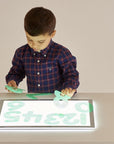 Child exploring shapes and colors on the Tickit A3 Rectangular Light Panel with bright LED illumination.