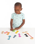Child playing with Rainbow Wooden Keys in various colors, engaging in sorting and counting activities.