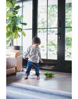 A toddler joyfully playing with the Pull Toy – Alligator in a bright living room.
