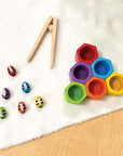 Colorful Beehives set from PlanToys featuring bees, hives, and tweezers for fine motor skills.