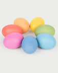 Rainbow Wooden Eggs in vibrant colors arranged in a playful circle on a light background.