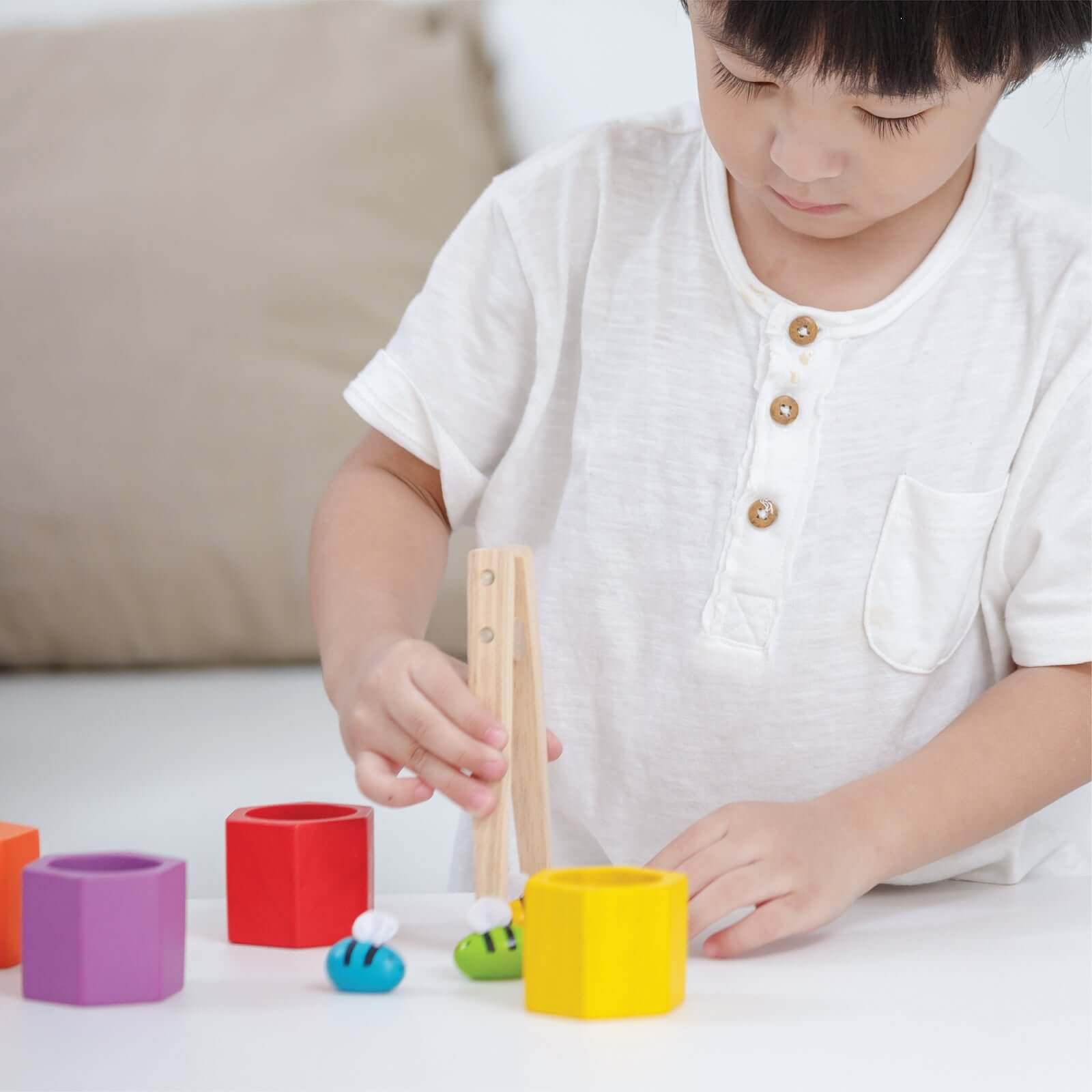 A child engaged in The Deep Thinker collection, exploring colors and shapes with hands-on play.