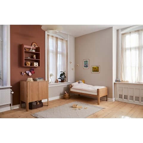FLEXA Nova Junior Bed in oak, minimalist design, and softly rounded edges in a cozy children's bedroom.