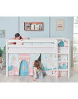 Two children playing with a high bed featuring a safety rail and colorful themed curtains, in a bright room.