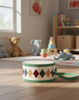 Small drum with diamond pattern and green accents on in a nursery