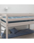High bed with safety rail and blue mattress, designed for comfort and space efficiency, perfect for kids' rooms.