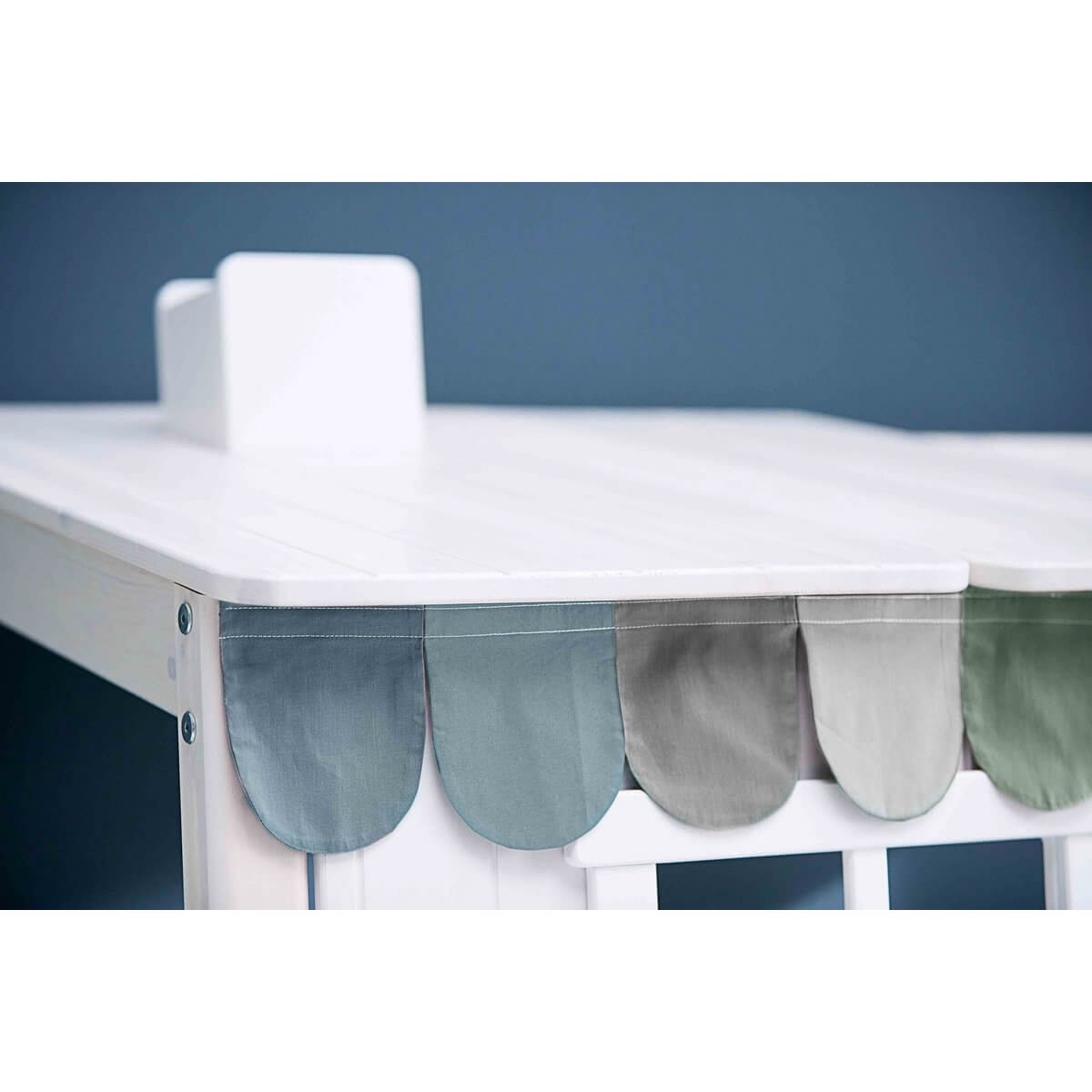 Stylish fabric drape in soft hues on a white table, enhancing a playful and cozy nursery or child's room decor.