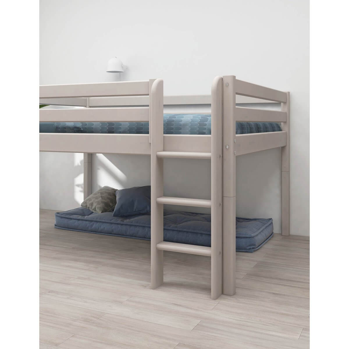High bed with safety rail and ladder, white frame, featuring a cozy area underneath for play or storage.