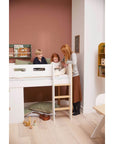 Children enjoying playtime on the FLEXA Nor High Bed with treehouse design, showcasing a cozy bedroom setting.