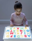 Child exploring colors and letters with the Tickit A3 Rectangular Light Panel.